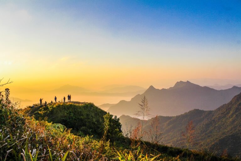 SHOWS photo of people standing on top of mountain near grasses 733162.jpg